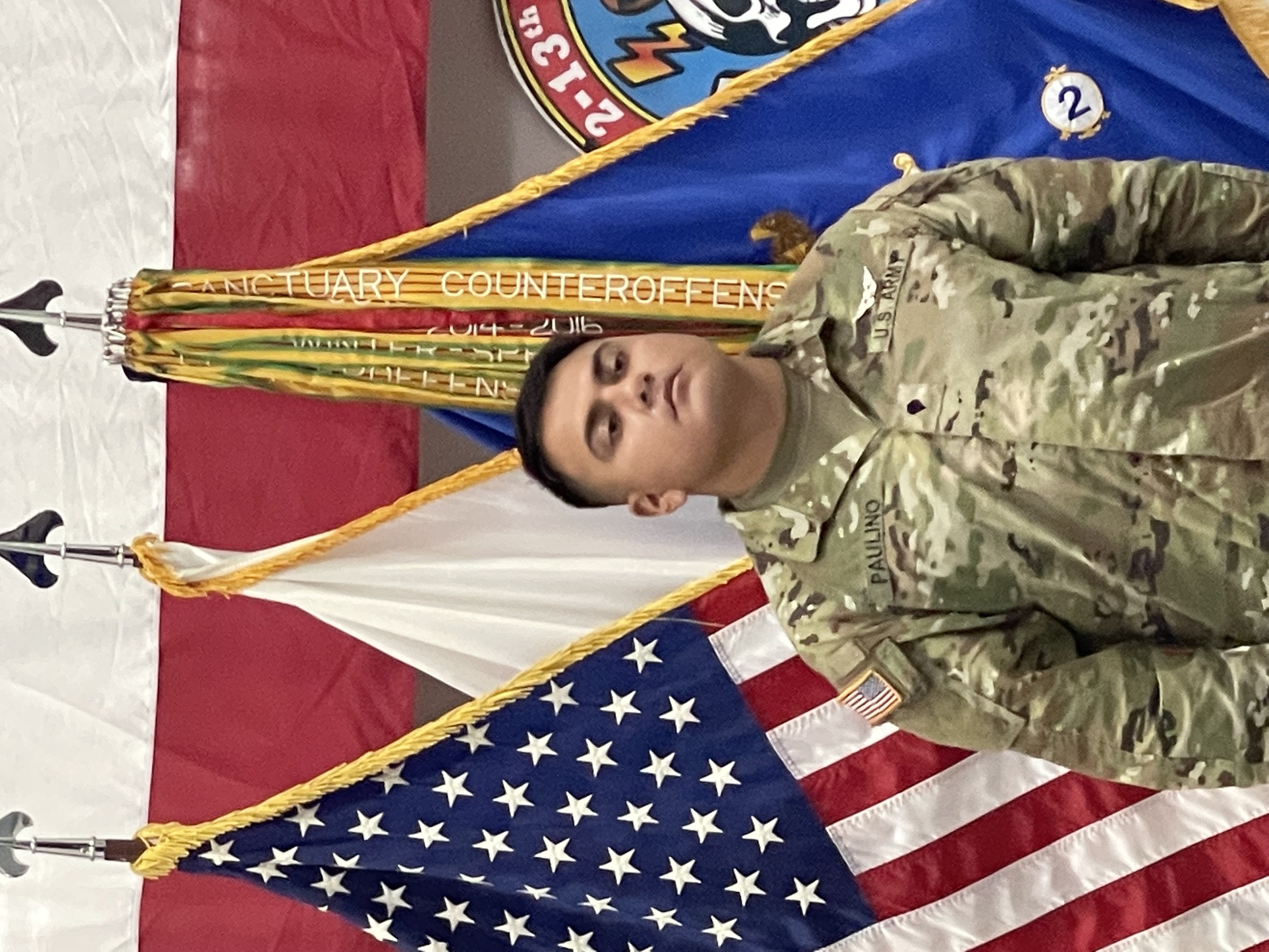 Rodolfo Antonio Paulino Hernandez standing in front of flags